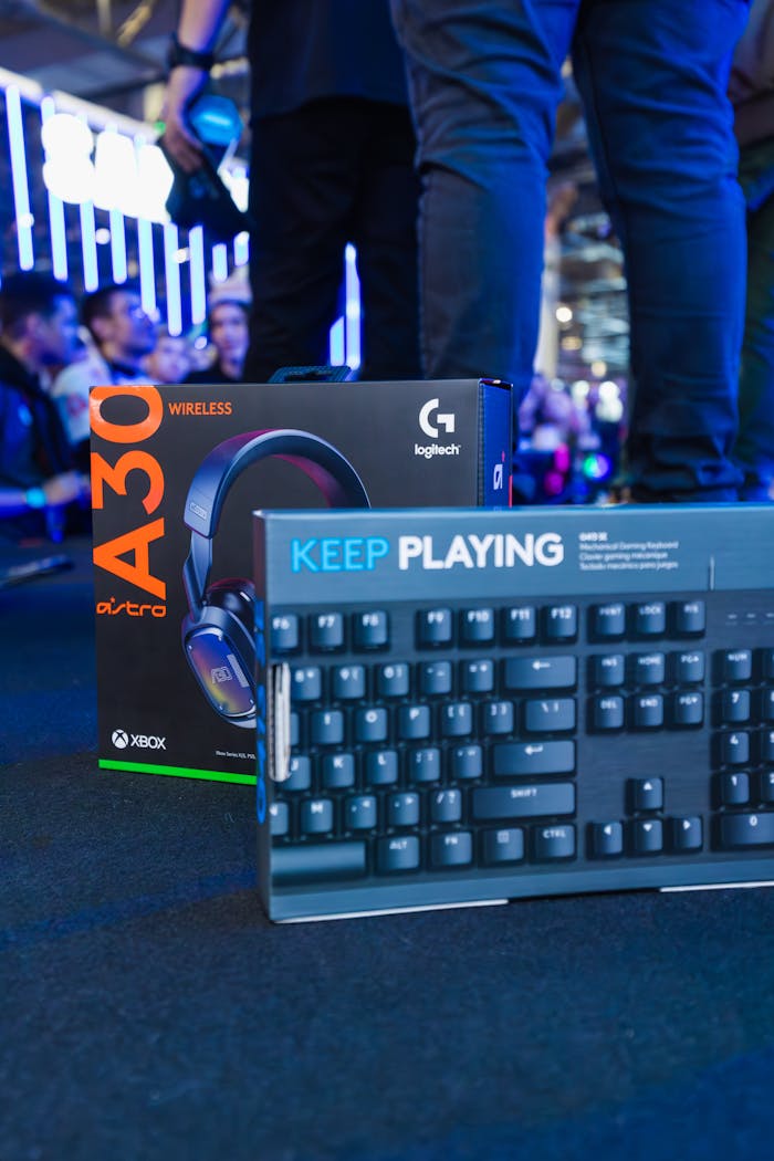 Astro A30 headset and Logitech keyboard showcased at a technology trade event.